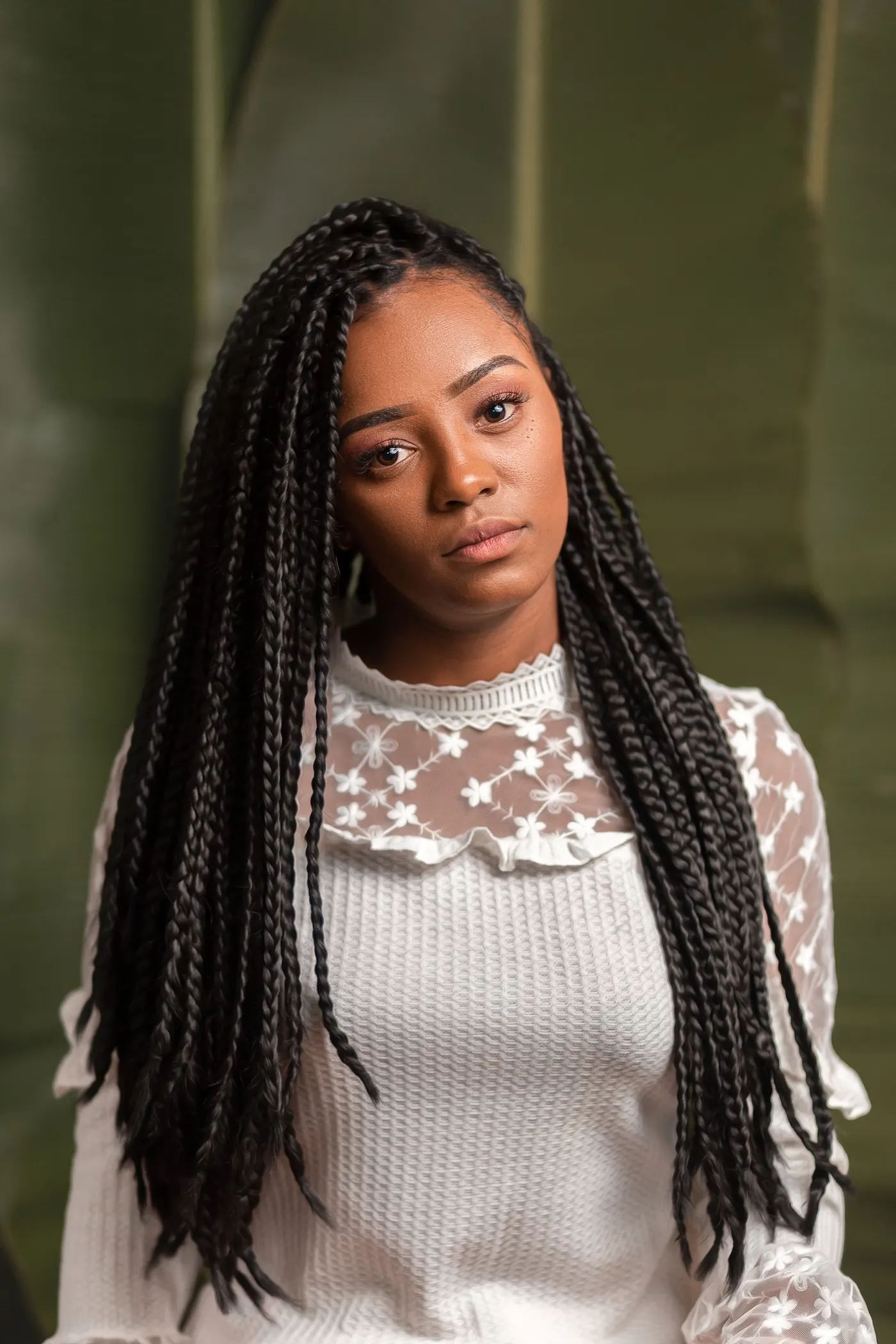 Long box braids styled with an elegant white lace top